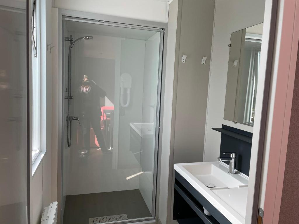une personne prenant une photo d'une douche dans une salle de bains dans l'établissement Mobilhome tout confort M9 domaine de Lanniron, à Quimper