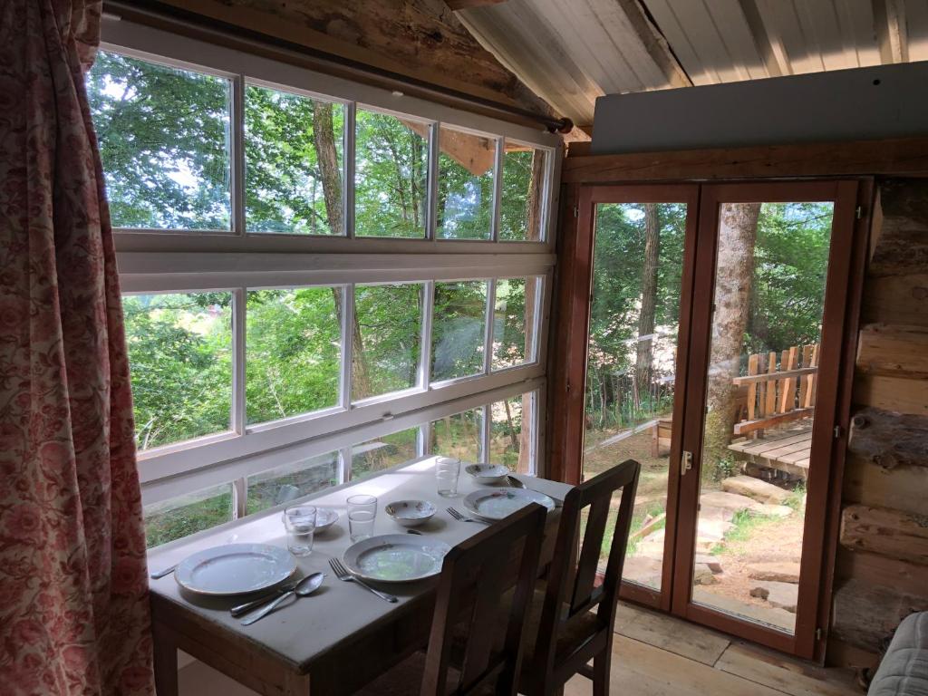 une salle à manger avec une table et une grande fenêtre dans l'établissement Fenêtre sur les Pyrénées, à Soulan