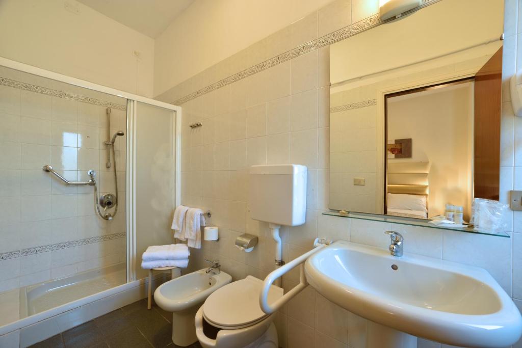 une salle de bain avec un lavabo, des toilettes et un miroir dans l'établissement Hotel Diano Marina Mhotelsgroup, à Diano Marina