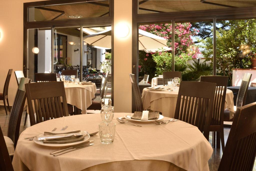 une salle à manger avec des tables et des nappes blanches dans l'établissement Hotel Diano Marina Mhotelsgroup, à Diano Marina