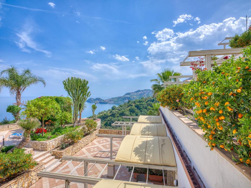 - une vue depuis le balcon d'une maison avec des parasols dans l'établissement Hotel Antares, à Letojanni
