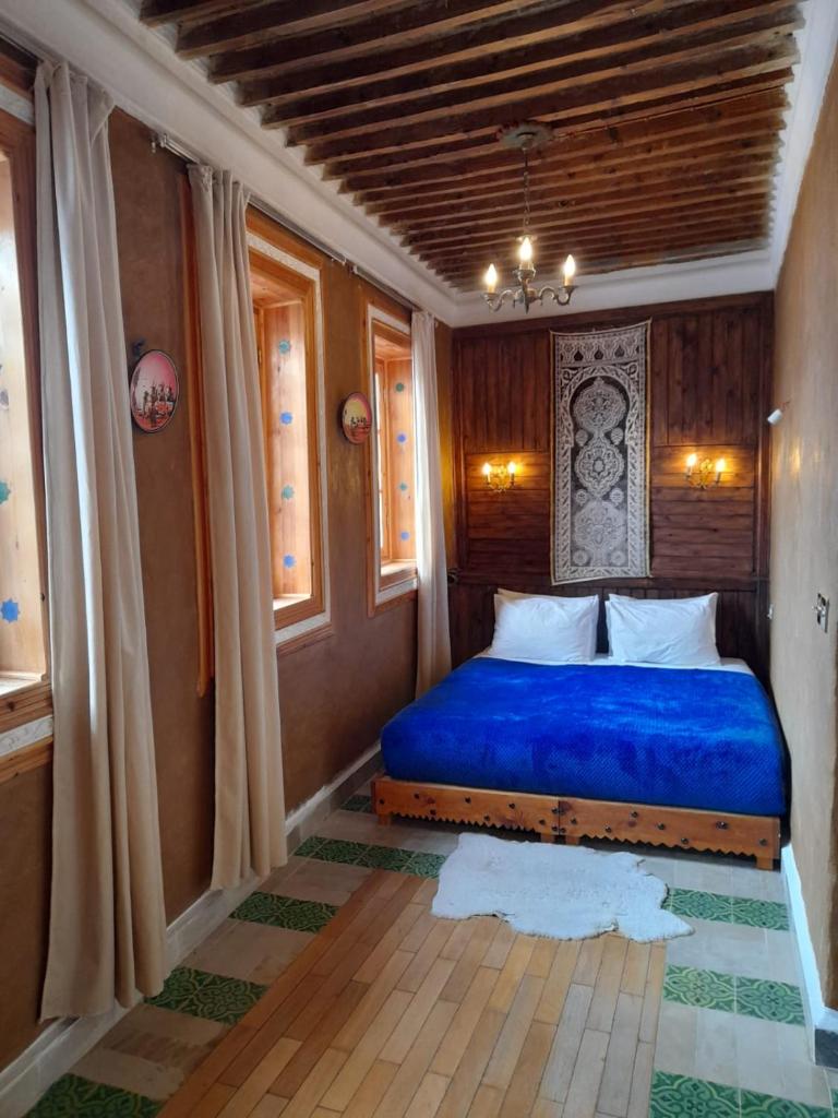 - une chambre avec un lit bleu dans l'établissement RIAD LA SANTA, à Chefchaouen