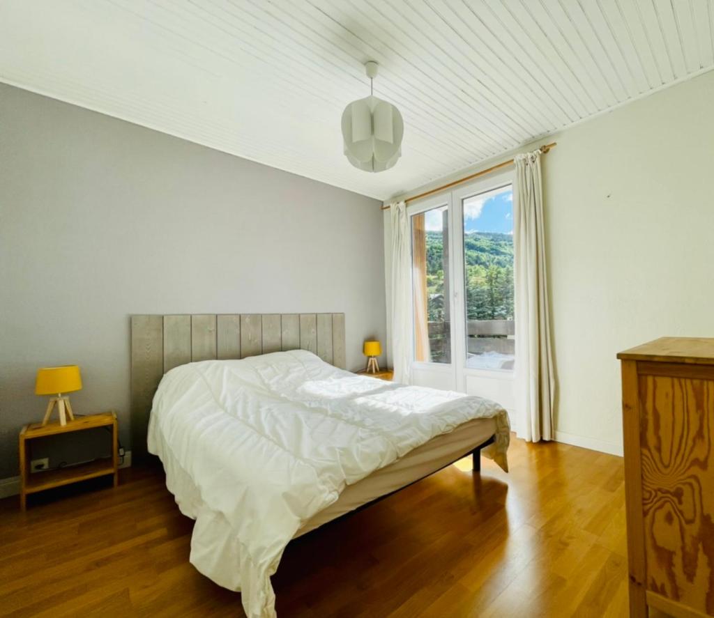 une chambre blanche avec un lit et une fenêtre dans l'établissement 75m With Balcony Near The Slopes!, à La Salle Les Alpes