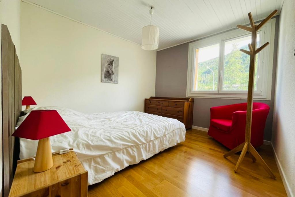 une chambre avec un lit et une chaise rouge dans l'établissement 75m With Balcony Near The Slopes!, à La Salle Les Alpes