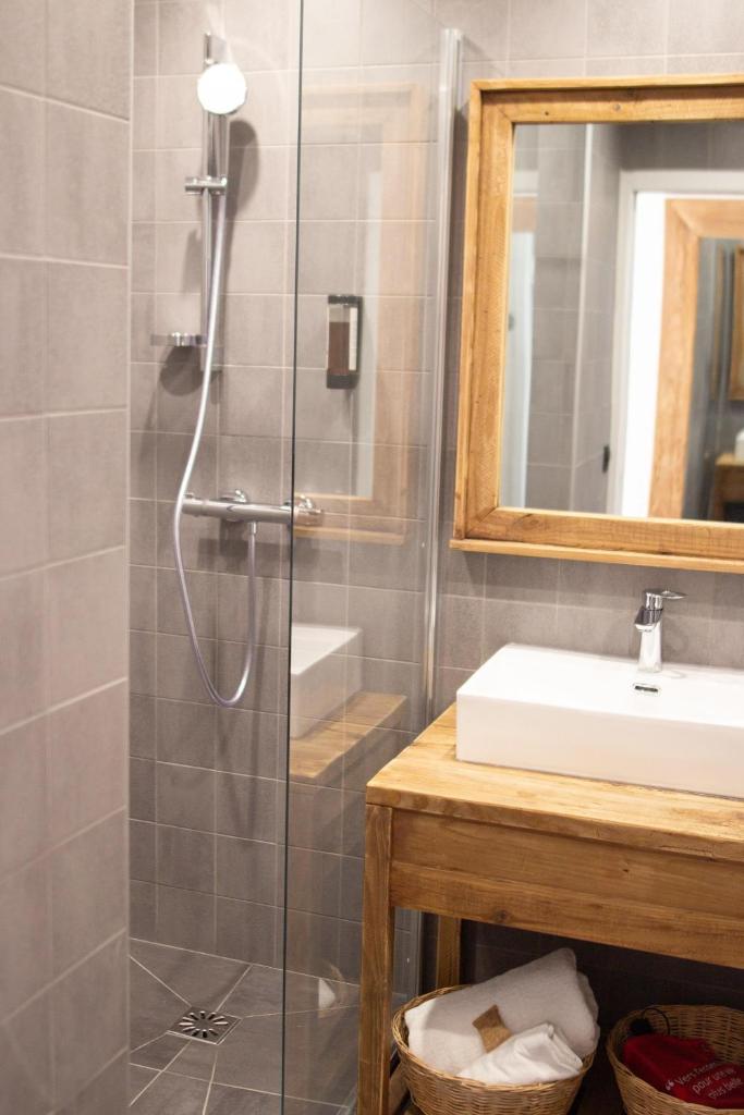 une salle de bain avec douche et lavabo dans l'établissement Hotel Lac Bleu 1650, à Saint-François-Longchamp 31 autres photos