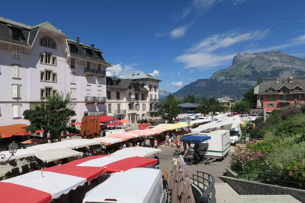 une rue avec des parasols et des bâtiments avec une montagne en arrière-plan dans l'établissement Saint-Gervais apartment next to Bettex ski lift, à Saint-Gervais-les-Bains