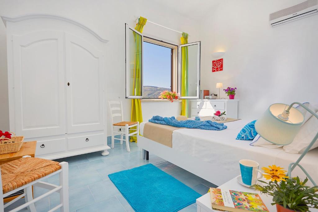 une chambre blanche avec un lit et une fenêtre dans l'établissement Villa Del Sol - Scopello-Villas, à Scopello