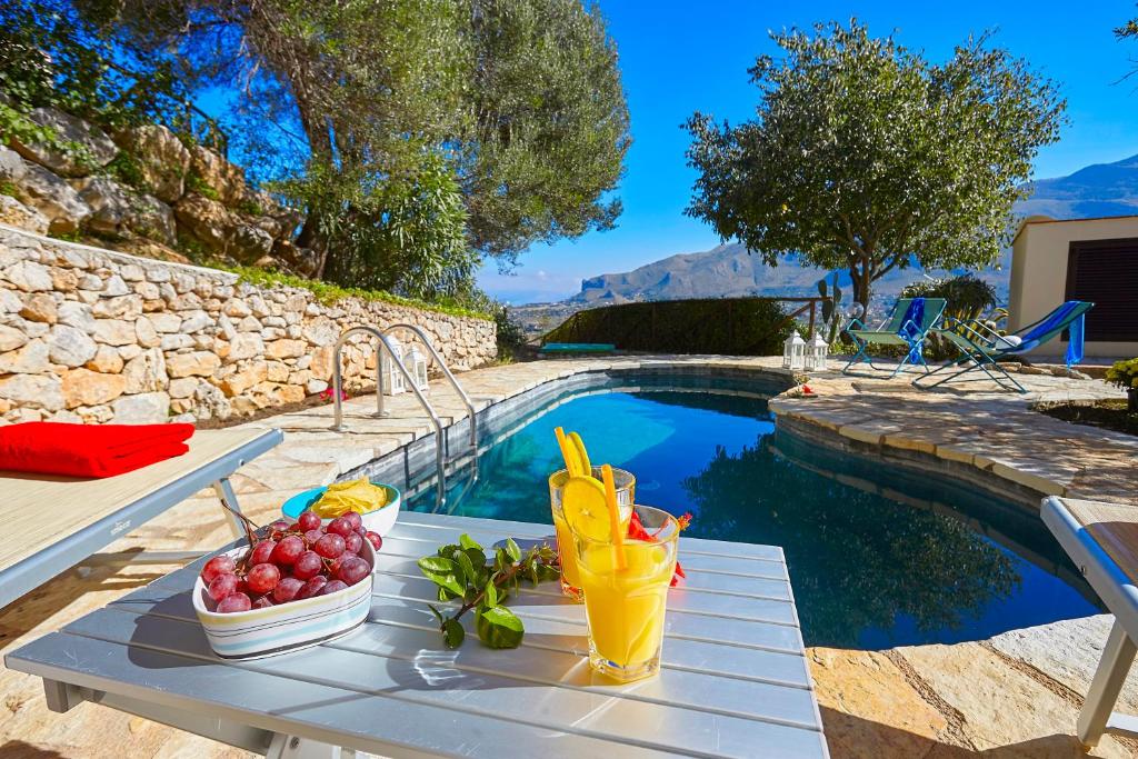 - une table avec des fruits à côté de la piscine dans l'établissement Villa Del Sol - Scopello-Villas, à Scopello