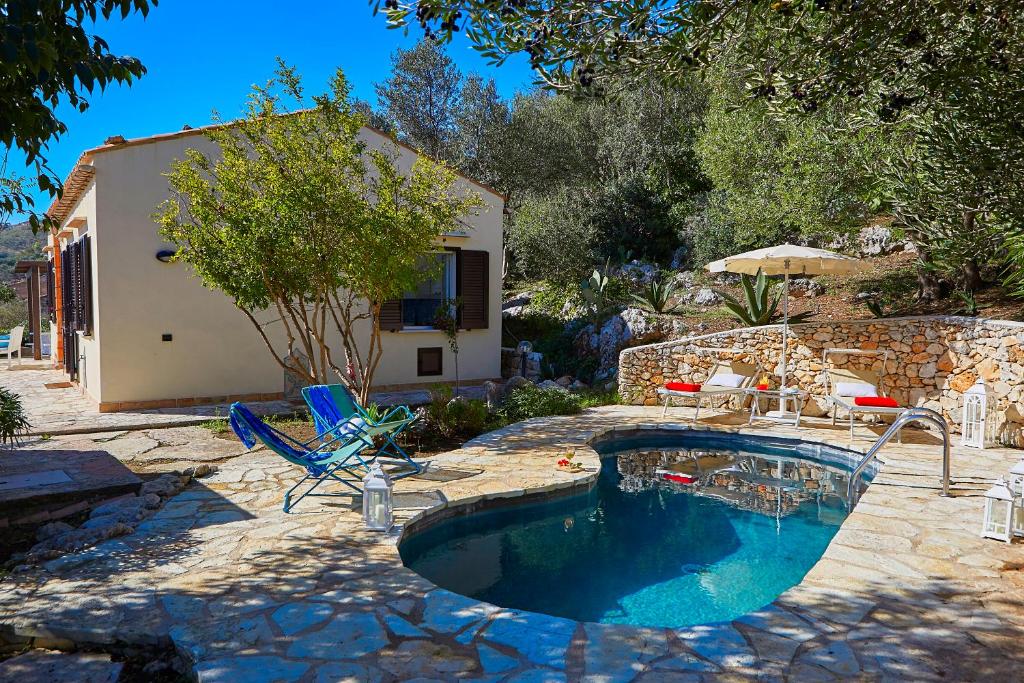 une piscine dans une cour avec des chaises et une maison dans l'établissement Villa Del Sol - Scopello-Villas, à Scopello