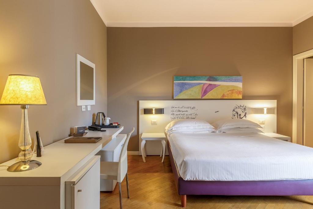une chambre d'hôtel avec un lit et un bureau dans l'établissement Hotel Residence Esplanade, à Viareggio