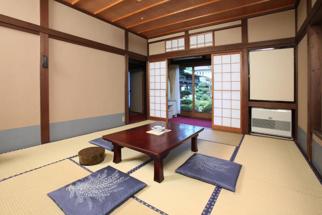 une pièce vide avec une table et des fenêtres dans l'établissement Shitanda, à Takayama