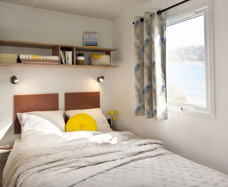 une chambre avec un grand lit avec une fenêtre dans l'établissement Camping de Graniers, à Monoblet