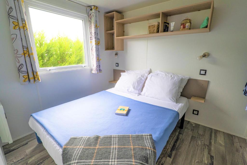 une chambre avec un lit avec un plateau dessus dans l'établissement Camping Country Park Touquin - Site Officiel - Next to Disneyland Paris, à Touquin