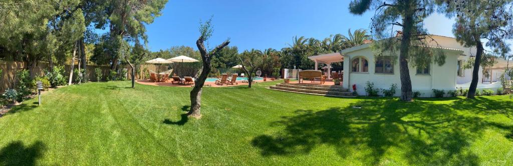 une petite maison dans une cour avec une pelouse verte dans l'établissement Villa Vittoria, à Vieste