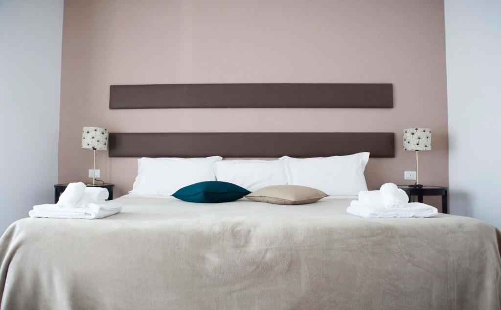 - un grand lit blanc avec 2 serviettes dans l'établissement Smy Civico Zero, à Tarquinia