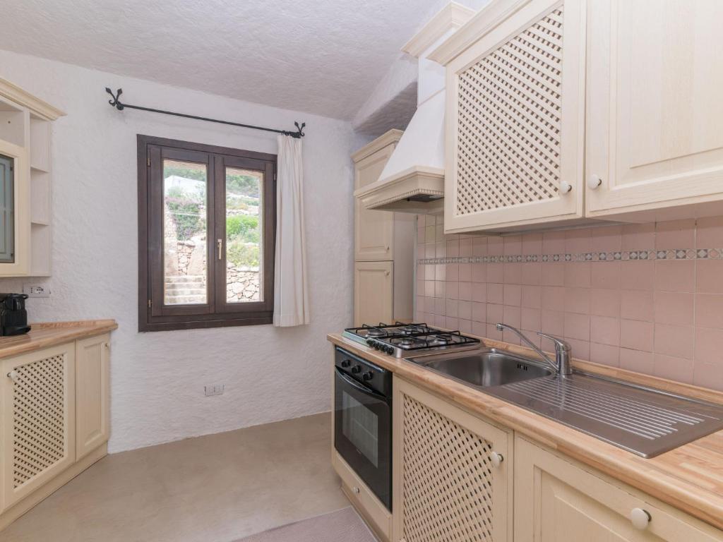 une cuisine avec un évier et une cuisinière four supérieur dans l'établissement Villa Paradiso by Interhome, à Porto Cervo 39 autres photos