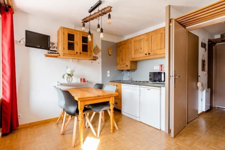 - une cuisine avec une table et des chaises en bois dans la chambre dans l'établissement Les gentianes 311, aux Menuires
