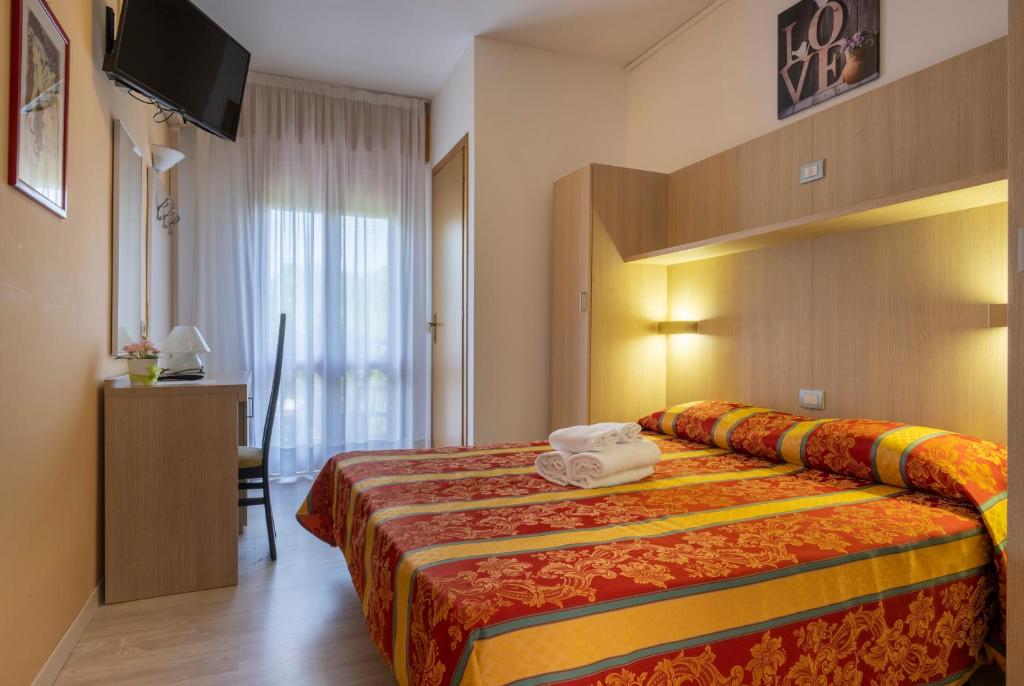 une chambre d'hôtel avec un lit avec des serviettes dessus dans l'établissement Hotel Ragno, à Lido di Jesolo