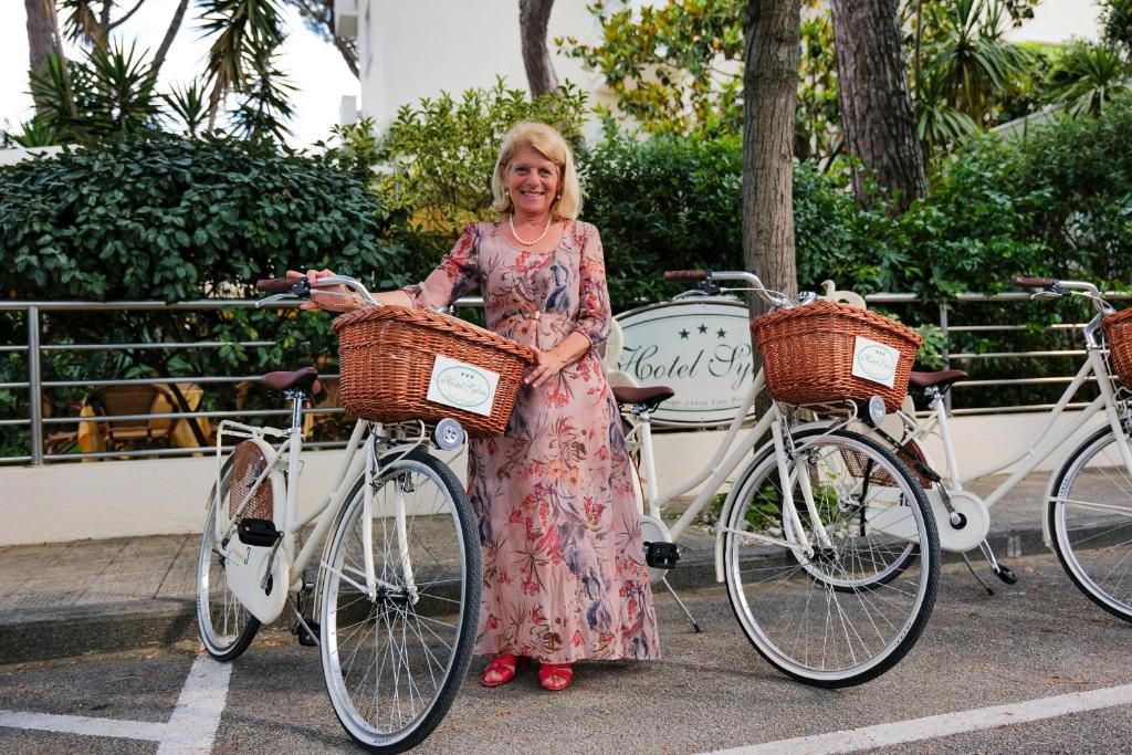 Une femme se tient à côté de deux vélos dans l'établissement Hotel Sylvia, à Lido di Camaiore