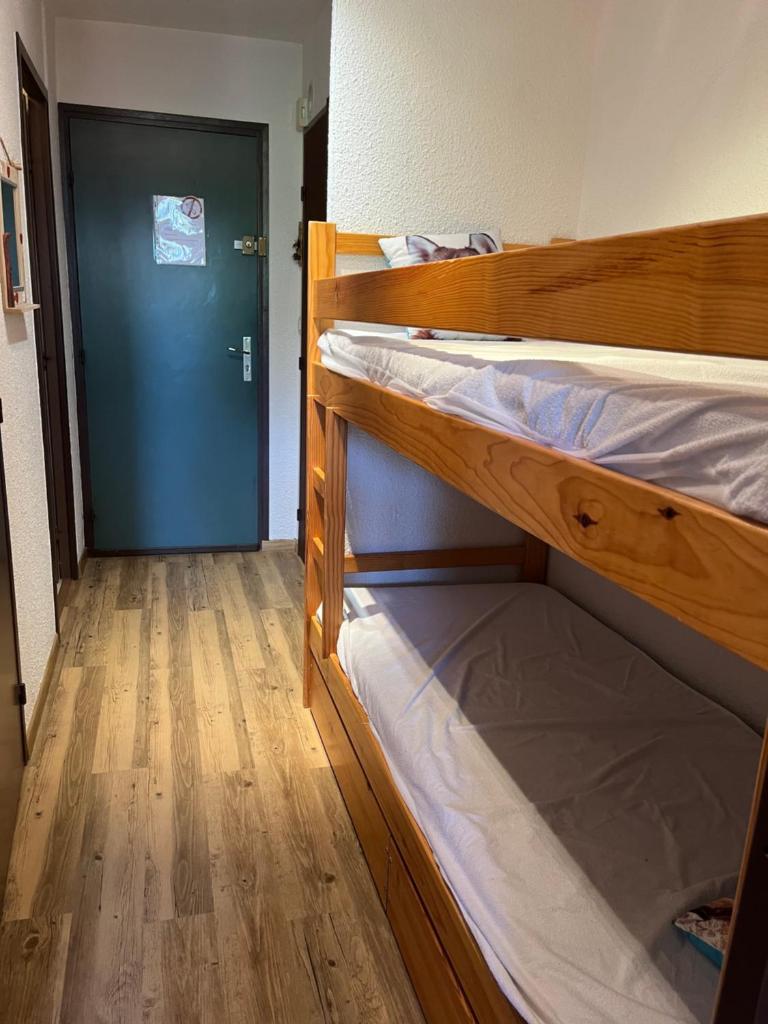 Cette chambre comprend 2 lits superposés et une porte bleue. dans l'établissement Très joli studio au calme et bien situé, à Orcières