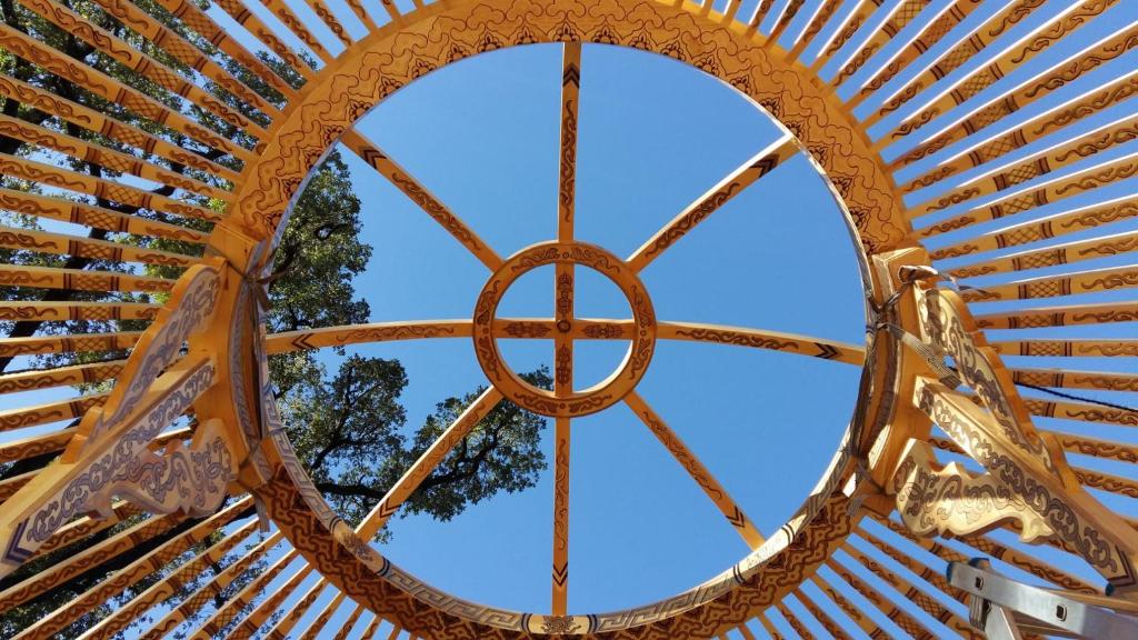 une vue depuis l'intérieur d'une structure en bois avec un arbre en arrière-plan dans l'établissement Yourte indépendante en pleine nature, proche d'Ajaccio, à Carbuccia 7 autres photos
