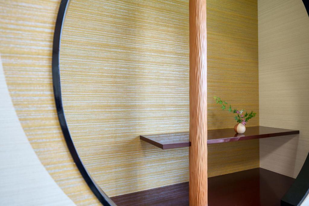 La salle de bains est pourvue d'un miroir et d'une plante sur une étagère. dans l'établissement Hitaonsen Hananoki River Terrace, à Hita