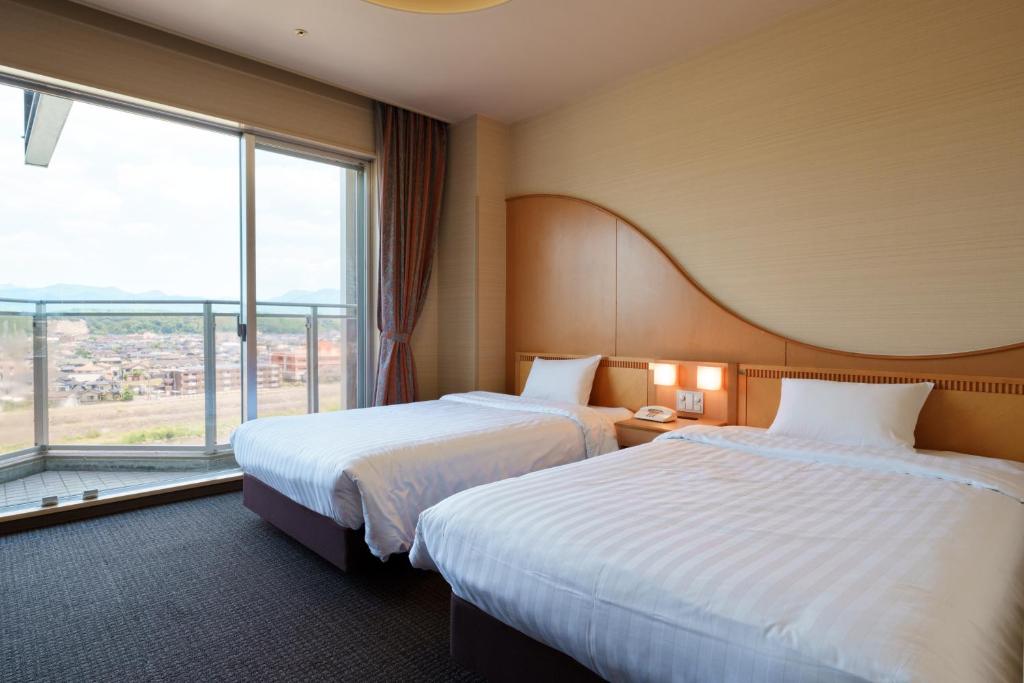 - 2 lits dans une chambre d'hôtel avec une grande fenêtre dans l'établissement Hitaonsen Hananoki River Terrace, à Hita 34 autres photos