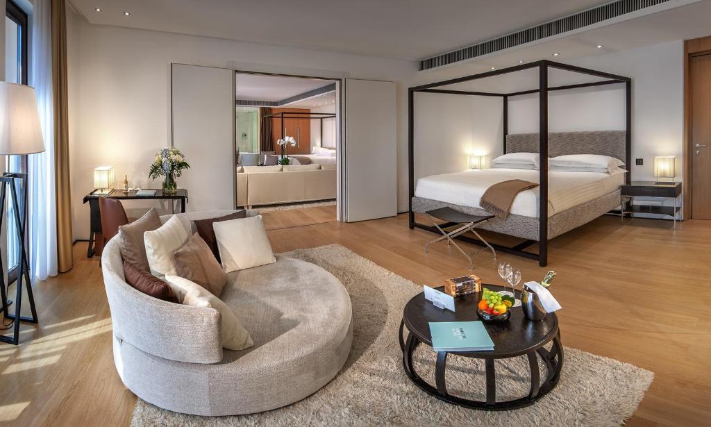 un salon avec un lit, un canapé et une table dans l'établissement Principe Forte Dei Marmi - Resort & Spa, à Forte dei Marmi 93 autres photos