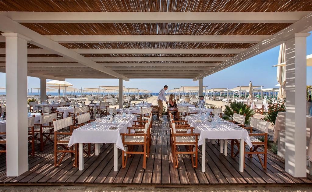 - un coin repas avec des tables et des chaises sur une terrasse dans l'établissement Principe Forte Dei Marmi - Resort & Spa, à Forte dei Marmi