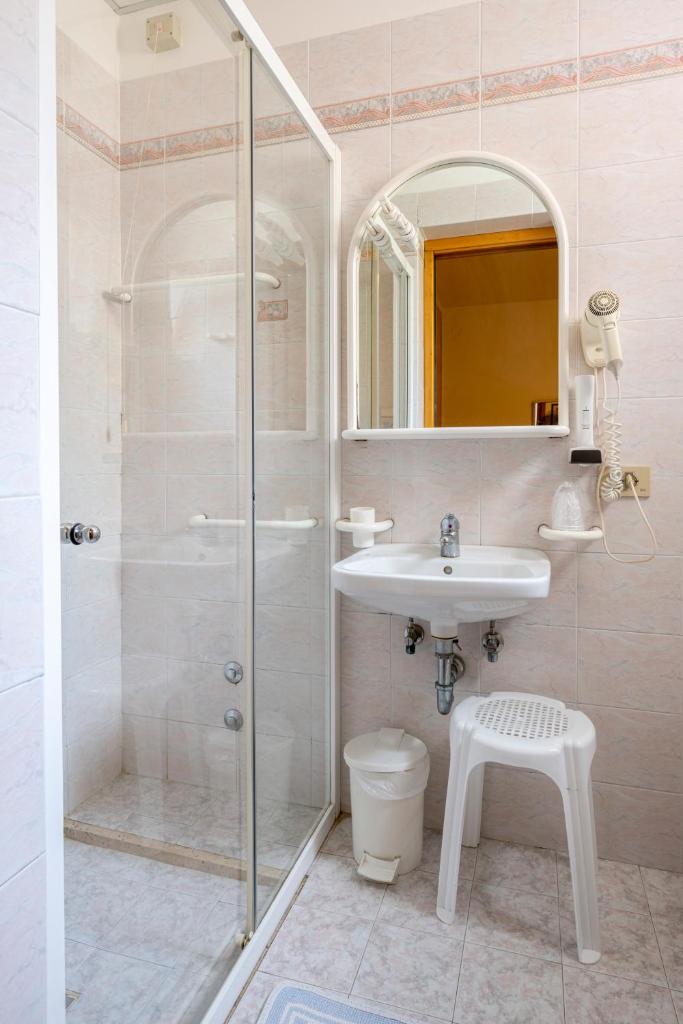 une salle de bain avec douche, lavabo et toilettes dans l'établissement Hotel Ragno, à Lido di Jesolo