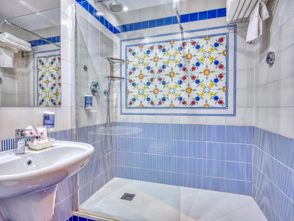 une salle de bain avec un lavabo et une douche dans l'établissement Hotel Caesar Palace, à Giardini Naxos