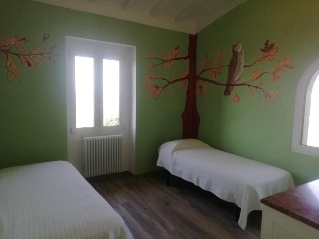 - une chambre avec 2 lits et une fresque murale sur les arbres dans l'établissement Casa Quercioli, à Pulicciano