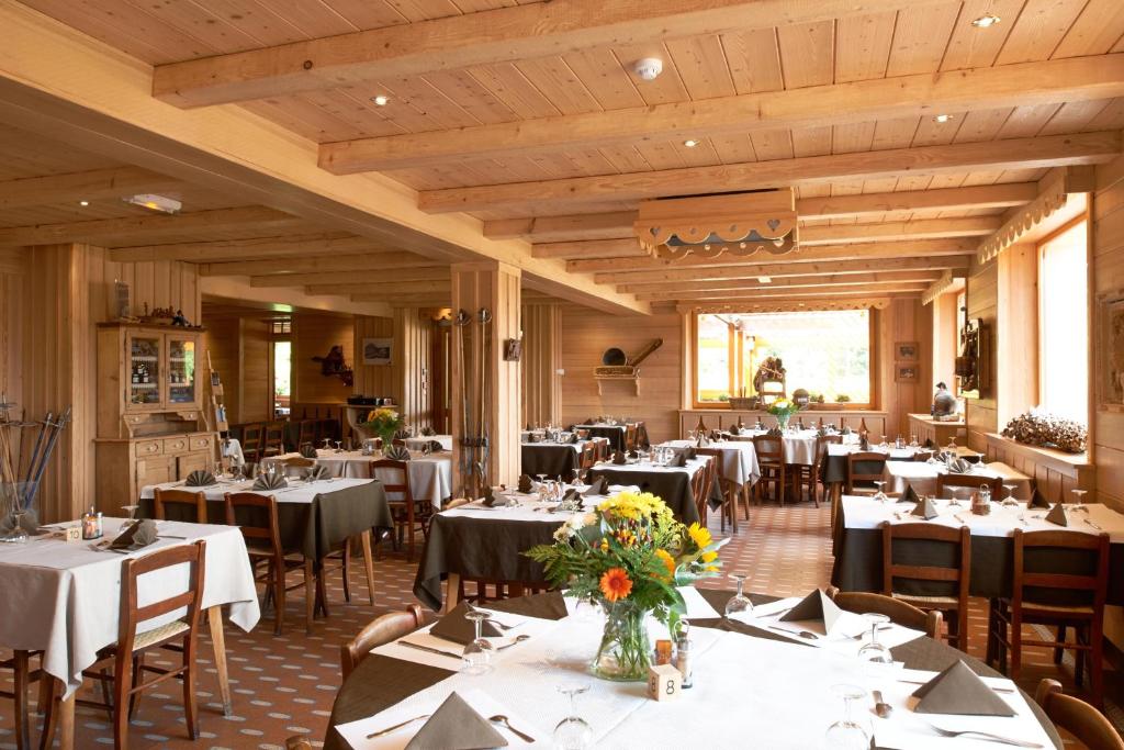 une salle à manger avec des tables et des chaises blanches dans l'établissement Hotel Restaurant Mont Champ du Feu, à Belmont