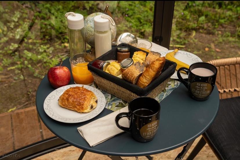 une table avec un plateau de petit-déjeuner dessus dans l'établissement Dôme Atmo'sphère, la tête dans les étoiles avec accès piscine, à Saint-Évarzec