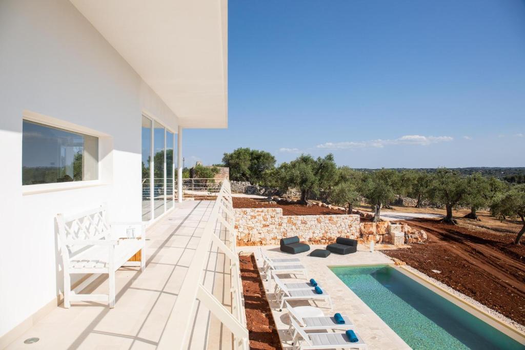 une terrasse avec des chaises et une piscine dans une maison dans l'établissement Villa Panitria, à Ostuni