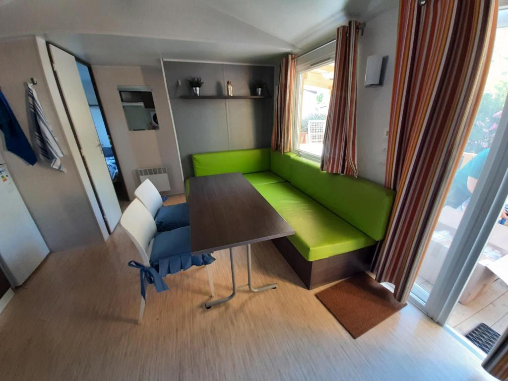 un salon avec un canapé vert et une table dans l'établissement mobile home entierement équipé, à La Roque-dʼAnthéron