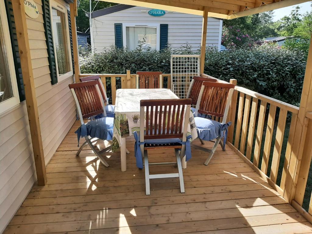 une terrasse en bois avec une table et des chaises dessus dans l'établissement mobile home entierement équipé, à La Roque-dʼAnthéron