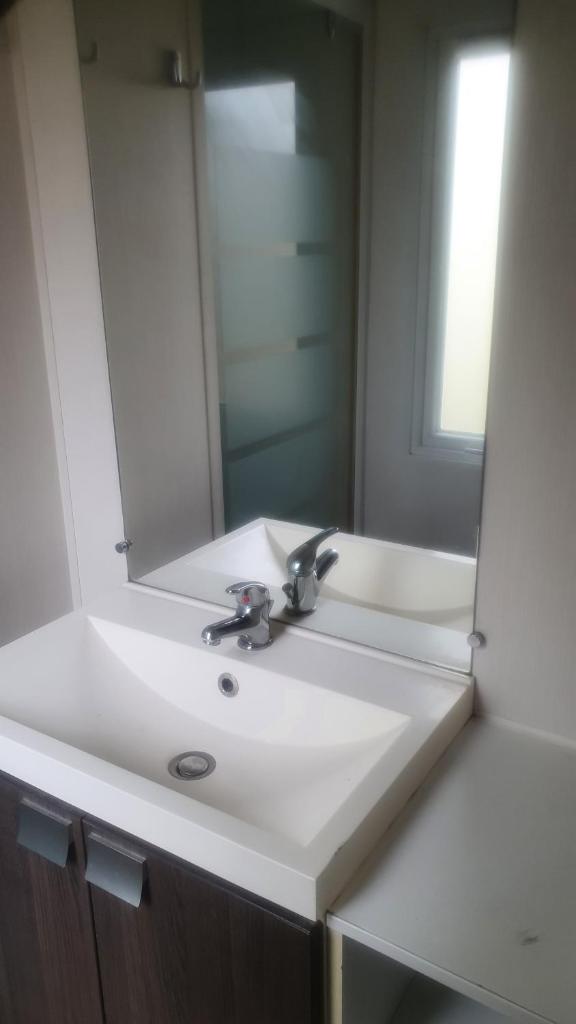 une salle de bain avec un lavabo blanc et un miroir dans l'établissement mobile home entierement équipé, à La Roque-dʼAnthéron 7 autres photos
