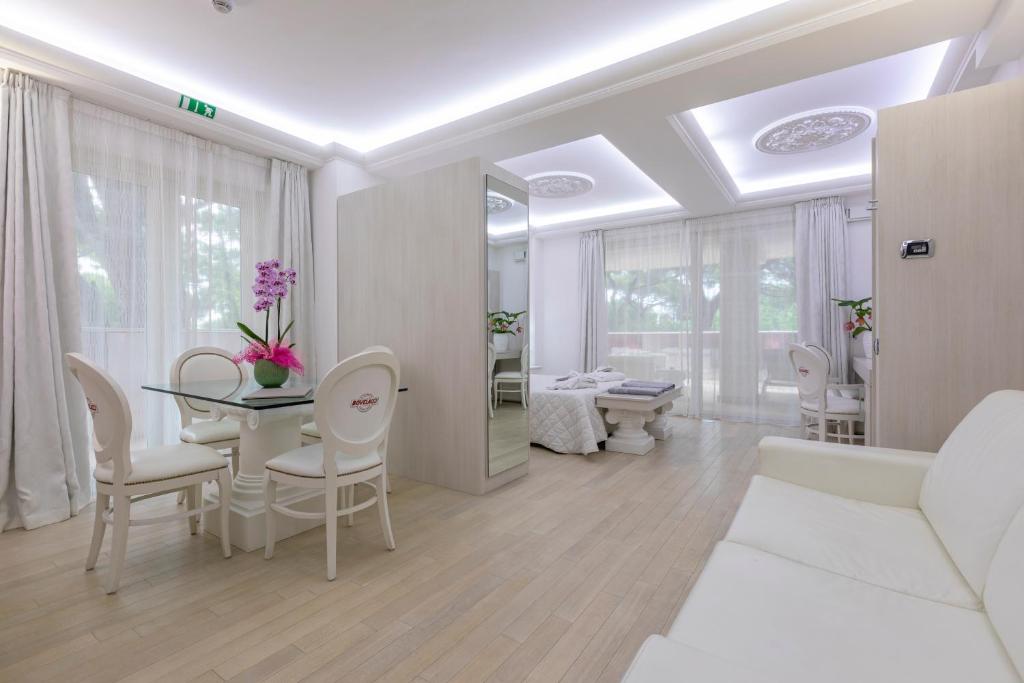un salon blanc avec une table et des chaises dans l'établissement Boutique Hotel Paradiso Bovelacci, à Milano Marittima