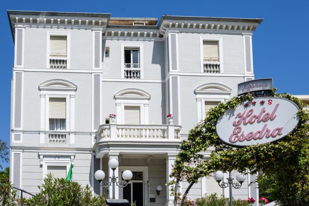 un bâtiment blanc avec un panneau devant dans l'établissement Esedra Hotel, à Rimini