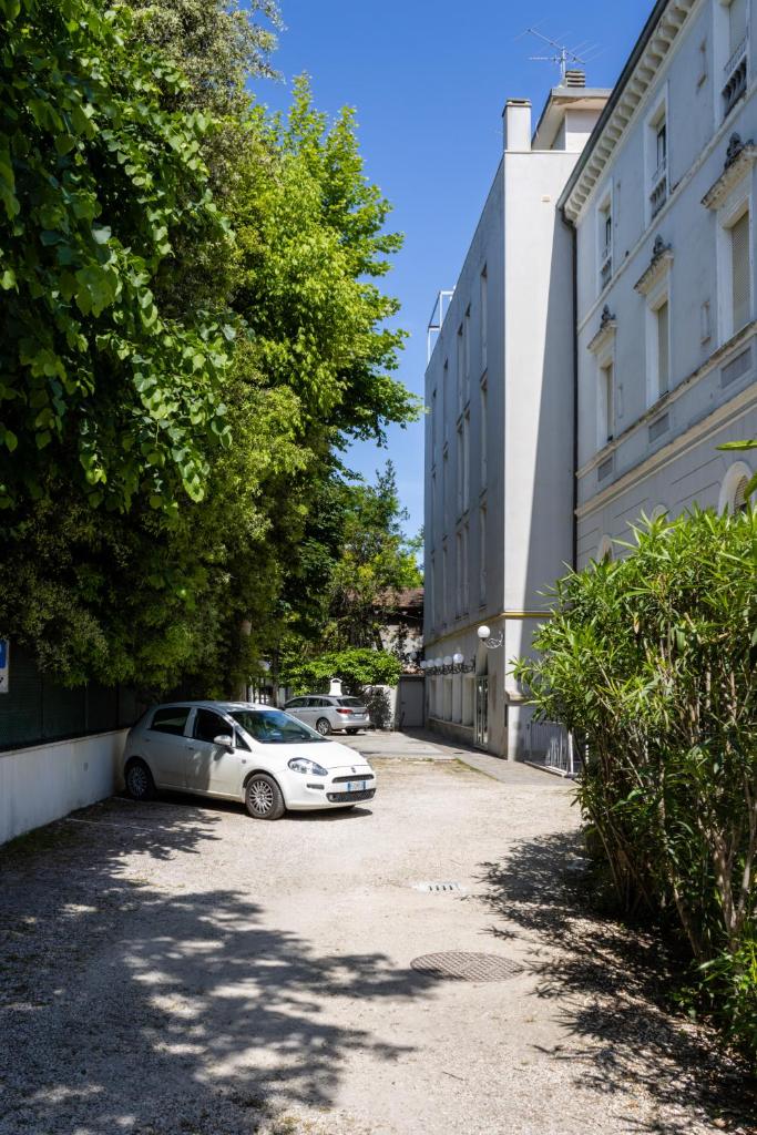 une voiture garée dans un parking à côté d'un bâtiment dans l'établissement Esedra Hotel, à Rimini