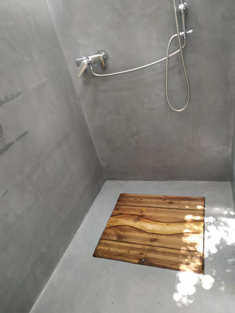La salle de bains est pourvue d'une douche et de parquet. dans l'établissement Eco Yourte Lac du Bourget, à Conjux