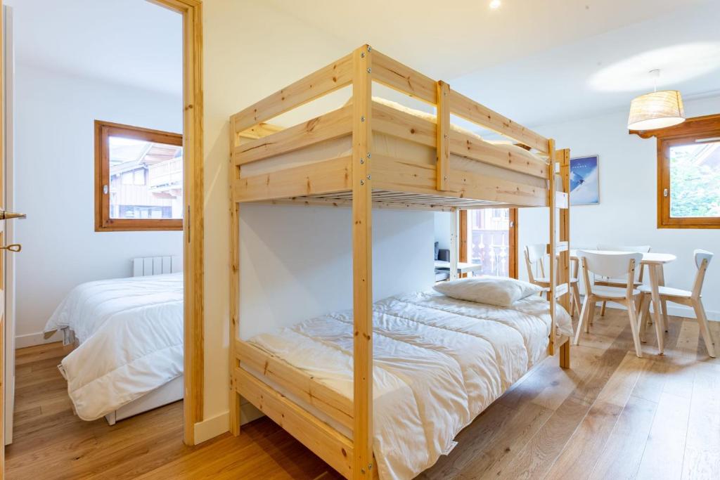 une chambre avec un lit superposé et une table dans l'établissement TRÈS LUMINEUX Cocon avec BALCON près des pistes, à Courchevel