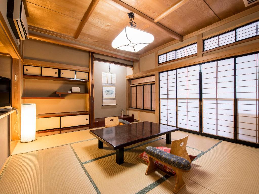 un salon avec une table et un canapé dans l'établissement Takanosukan, à Sekikawa