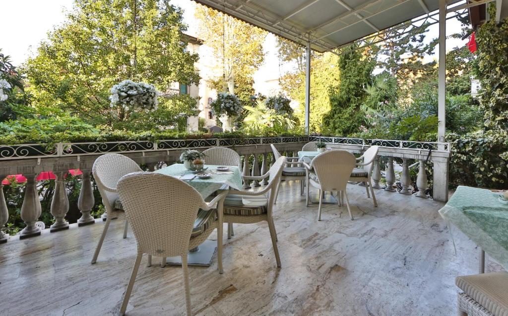 un patio avec une table et des chaises sur une terrasse dans l'établissement Hotel Biasutti, sur le Lido de Venise