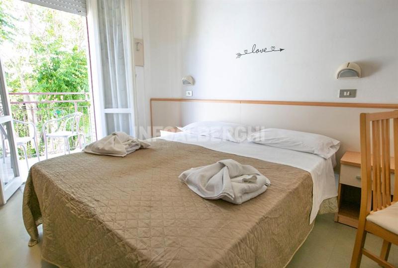 une chambre avec deux lits et une grande fenêtre dans l'établissement Hotel Paradiso, à Rimini