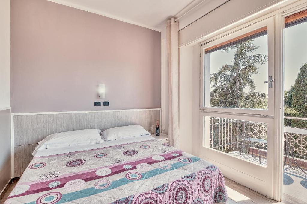 une chambre avec un lit et une grande fenêtre dans l'établissement Hotel Astoria, à Bordighera