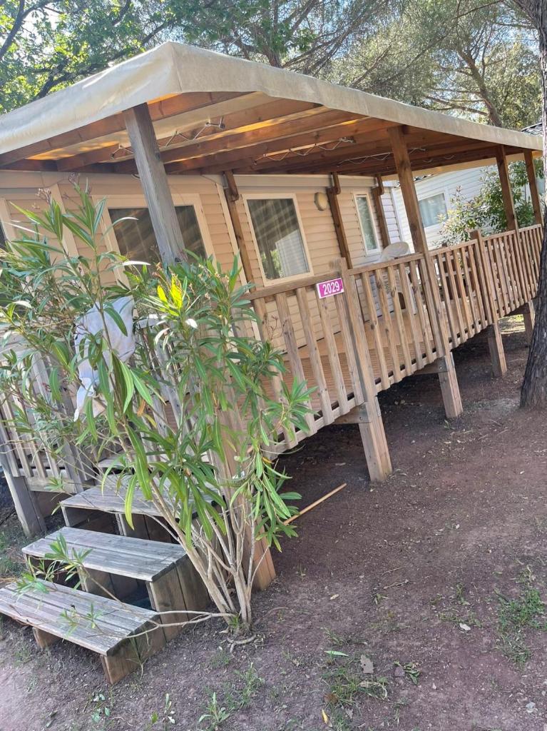 Ce chalet en bois dispose d'une terrasse couverte et d'escaliers. dans l'établissement Camping les Cigales - Mobil-home 4/6 personnes, au Muy 13 autres photos