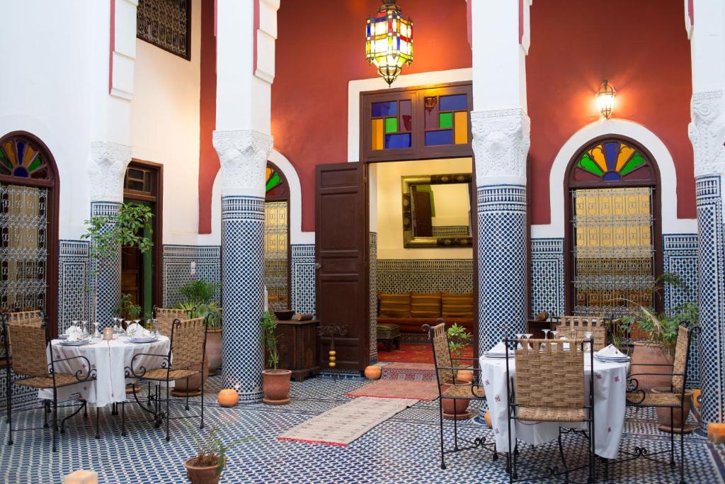 une cour avec des tables et des chaises dans un bâtiment dans l'établissement Riad Tafilalet, à Fès