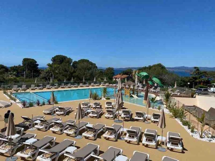 une grande piscine avec des chaises et des parasols dans l'établissement Camping L'ILE D'OR, à Saint-Raphaël